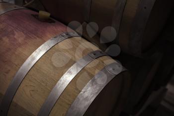 Wooden barrel with red wine in dark winery, close up photo with selective focus