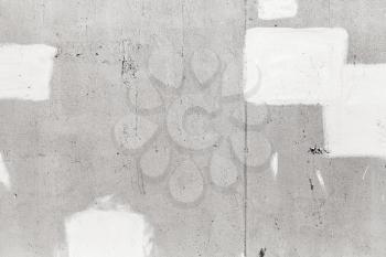 Gray concrete wall with white paint brush strokes, close-up background texture
