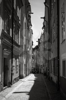 Black and white stylized photo. Old narrow street of Gamla stan, the old town in central Stockholm, Sweden