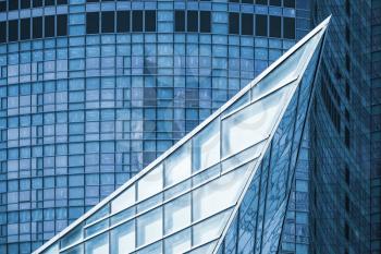 Modern architecture, abstract fragment, sharp corner made of glass and steel with reflections of blue sky