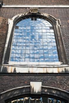 Old classic arched window perspective in dark brick wall, London, United Kingdom