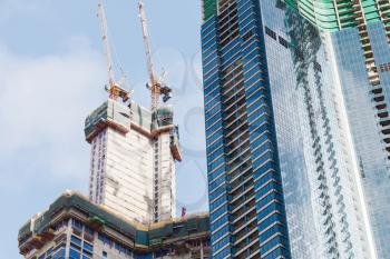 Construction cranes. Modern living house under construction. Block of flats development. Busan, South Korea