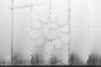 Gray industrial metal wall with rivets pattern. Background photo texture, front view