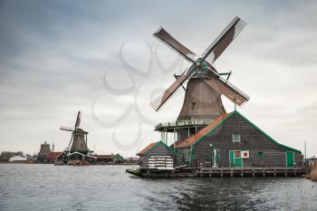 Windmills on Zaan river coast, Zaanse Schans town, popular tourist attractions of the Netherlands. Suburb of Amsterdam