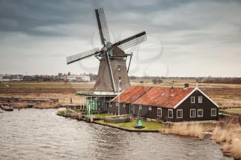 Windmill on Zaan river coast, Zaanse Schans town, popular tourist attractions of the Netherlands. Suburb of Amsterdam