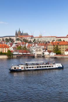 Small passenger ship goes on Vltava river. Prague in summer. Czech Republic
