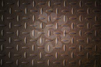 Dark rusted diamond plate metal wall pattern. Background photo texture, front view
