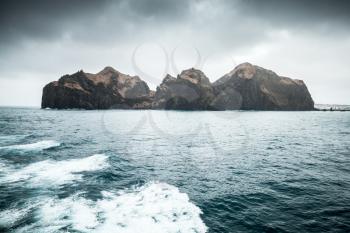 Seaside view of Vestmannaeyjar island in dark cloudy day, Iceland