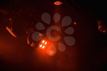 Red lights, strong spot beams in smoke over dark background, modern stage  illumination equipment