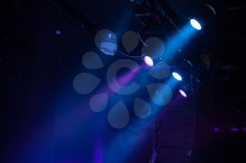 Blue spot lights. Beams and smoke over dark background, modern stage illumination