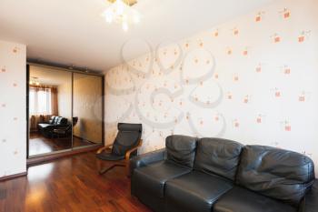 Contemporary living room interior with black leather chair and sofa