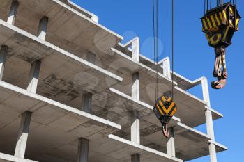 Crane hooks and new concrete building is under construction