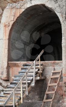 Dark portal of old concrete tunnel in the rock