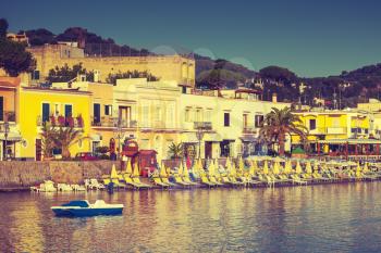 Main coastal street of Lacco Ameno. Ischia island, Mediterranean Sea coast, Bay of Naples, Italy. Vintage stylized photo with warm tonal correction retro filter effect