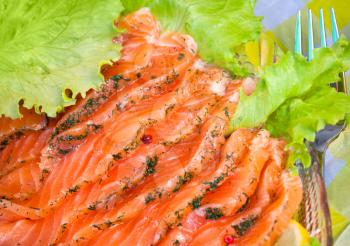 Close-up photo of smoked salmon slices served with salad and dill