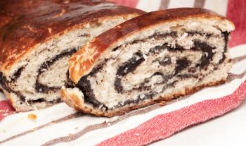 Closeup photo of sweet fresh homemade roll with poppy seeds