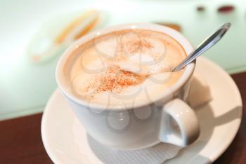 Cup of cappuccino with cinnamon on the table