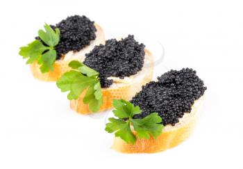 Three small sandwiches with black caviar isolated on white
