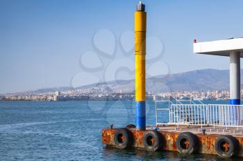 Yellow lighthouse pole on the pier in Izmir city, Turkey