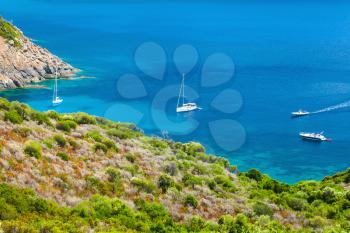 Corsica, French island in Mediterranean Sea. Coastal summer landscape with pleasure yachts moored in azure bay