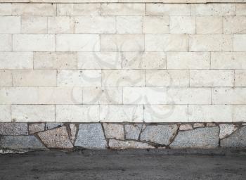 Urban background texture with stone wall and asphalt ground