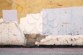 Abstract empty abandoned urban courtyard fragment, old colorful wall and road pavement