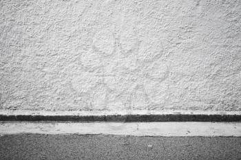 Abstract empty urban interior background texture with white grungy concrete wall and asphalt road pavement