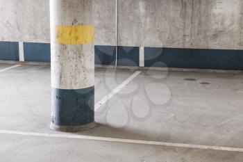 Empty underground parking interior fragment, round concrete column 