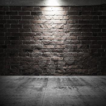 Abstract dark interior background with concrete floor and brick wall with spot light illumination