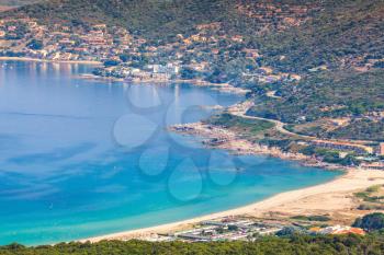 Summer coastal landscape of French island Corsica. Small azure bay with beach. Piana region, France
