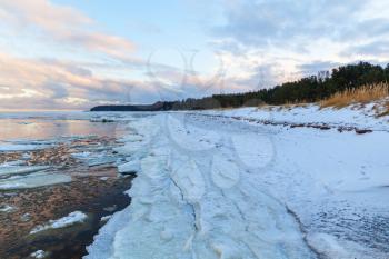 Winter coastal landscape with ice and snow on the beach. Gulf of Finland, Baltic Sea, Russia