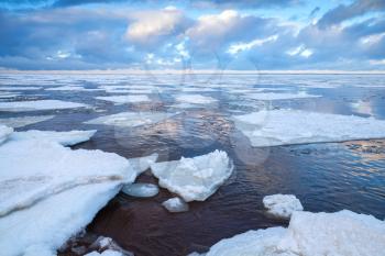 Winter coastal landscape with big floating ice fragments on cold water. Gulf of Finland, Russia