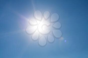 Real photo lens glow effect of sun on clear blue sky