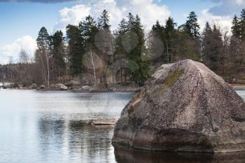 Still lake coastal landscape with big stone laying in water, Monrepo park, Vyborg Bay, Russia