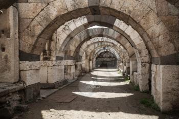 Empty stone corridor with arcs and columns. Ruins of Ancient city Smyrna. Izmir, Turkey