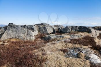 Norwegian mountain landscape, dark gray rocks under blue sky