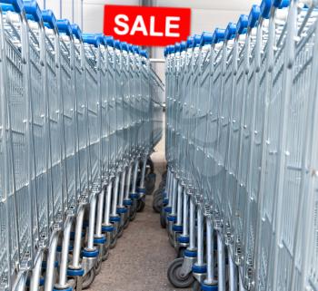 Supermarket shopping carts with SALE text label on a background