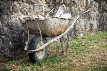 Old construction wheelbarrow stands against the wall