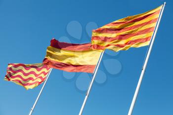 Flags of Spain, Catalonia and Tarragona city above blue sky