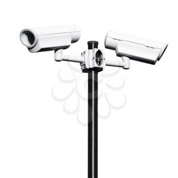 Two closed-circuit television cameras mounted on black pole isolated on white