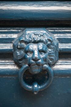 Old blue door knocker in shape of lion head