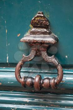 Old rusted knocker on green wooden door in Paris, France