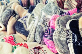 Many knitted woolen socks on the counter. Vintage toned photo with filter effect