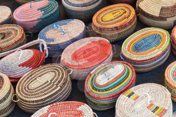 Colorful African wicker baskets stand on a counter in marketplace