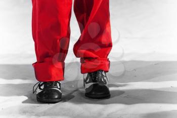 Fun man's legs with red pants and black white shoes on white background