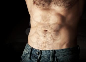 Flat sporty male belly. Close up photo on dark background