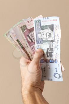 Modern Saudi Arabia money, banknotes in male hand, close-up photo