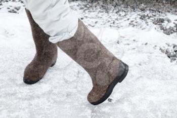 Dancing feet with traditional Russian felt boots on winter snowy road