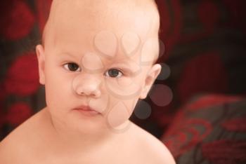Caucasian baby girl close-up portrait on dark blurred background