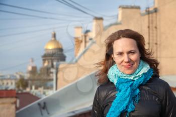 Outdoor portrait of young smiling Caucasian woman on the rooftop in St.Petersburg, Russia